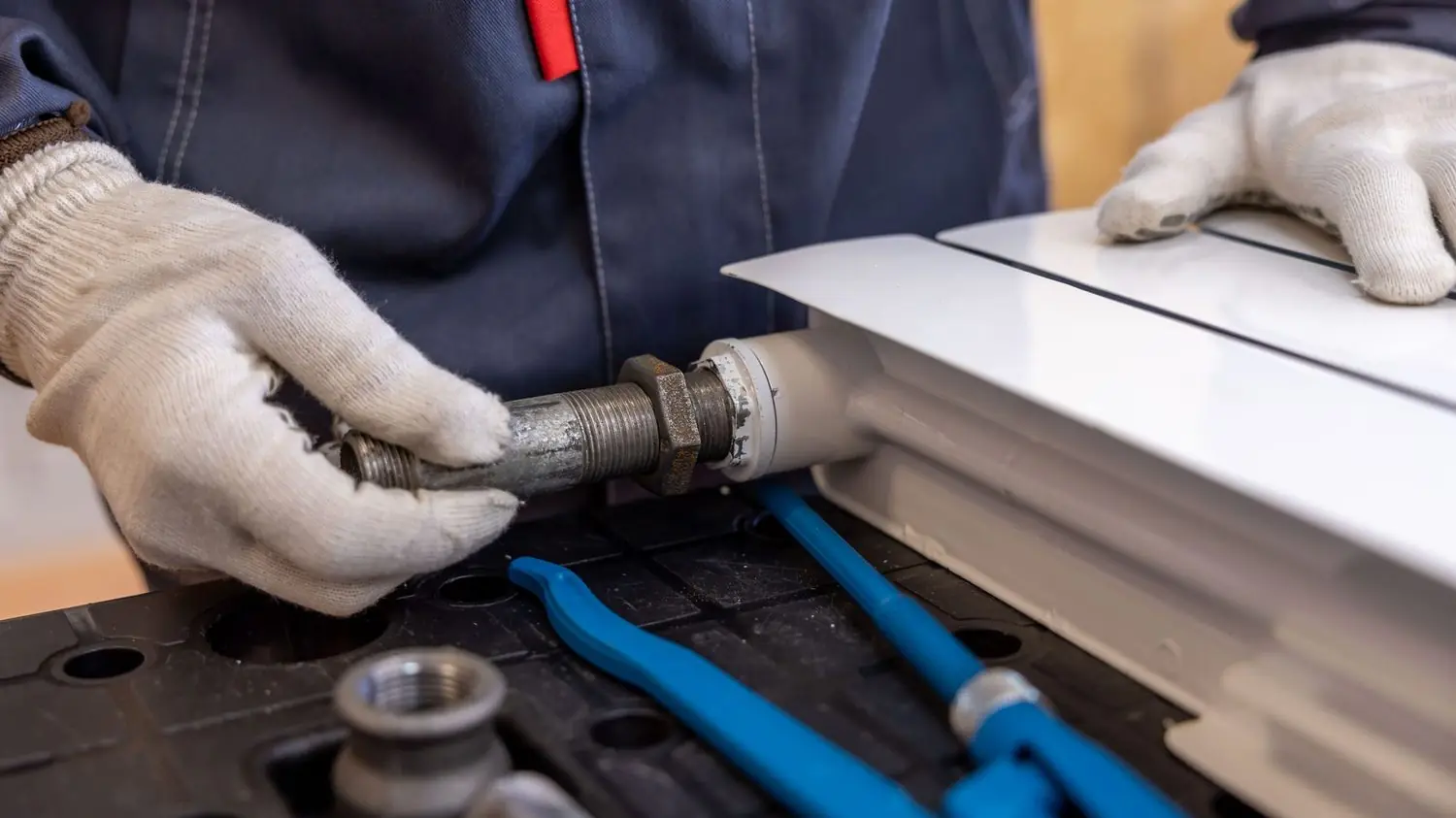 Plumber fitting a pipe with a wrench